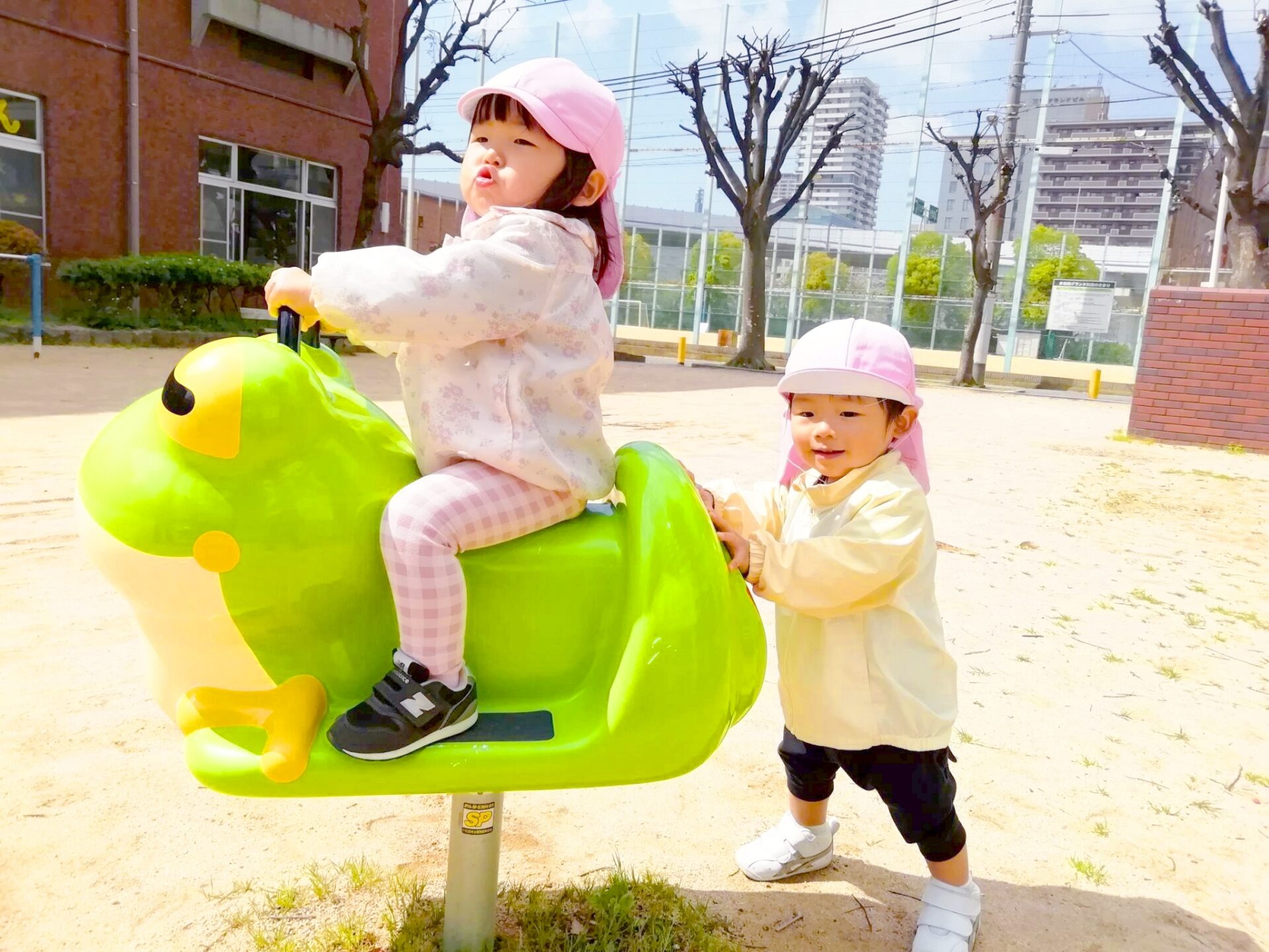 カエルの遊具で遊ぶ園児2人