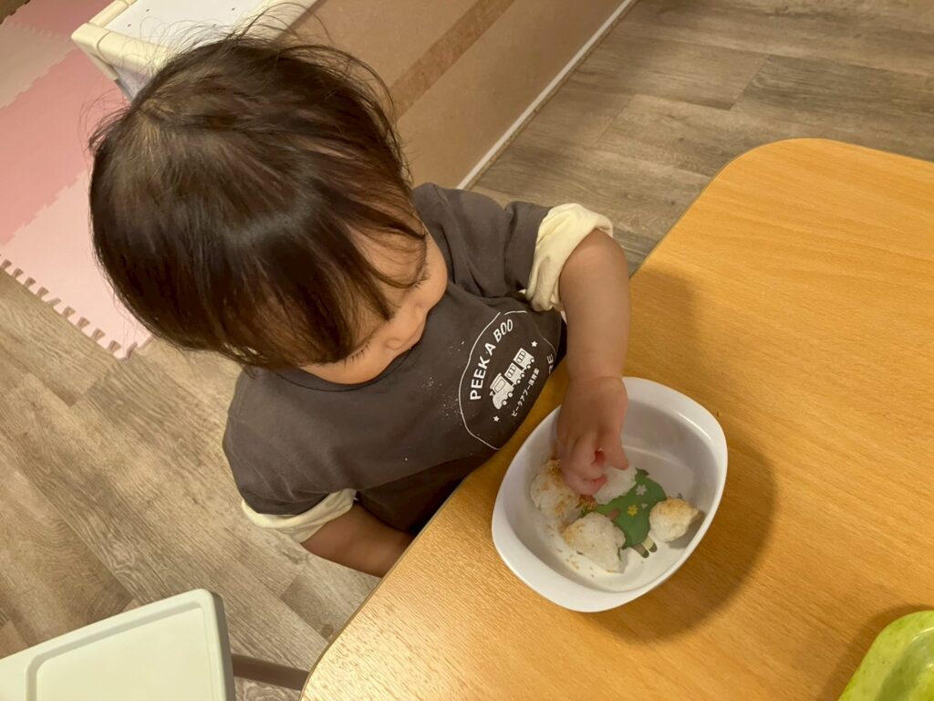 朝のおやつにきなこおにぎりを食べる園児