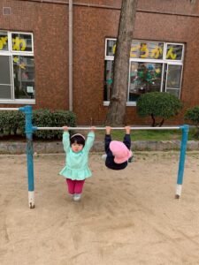 PEEK A BOO保育園 三宮園近くの公園の鉄棒で遊ぶ園児2人