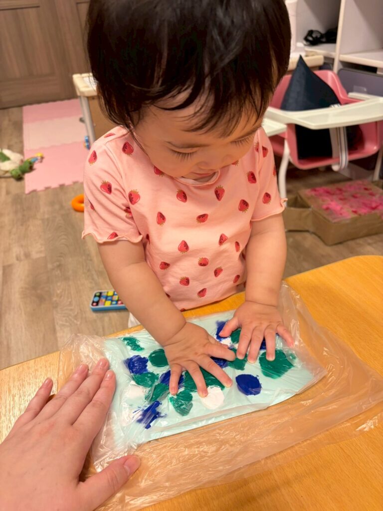 七夕の飾りつけを作成する0歳児の女の子