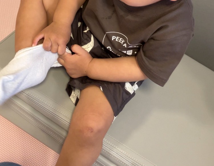 靴下を一生懸命履こうとする1歳児