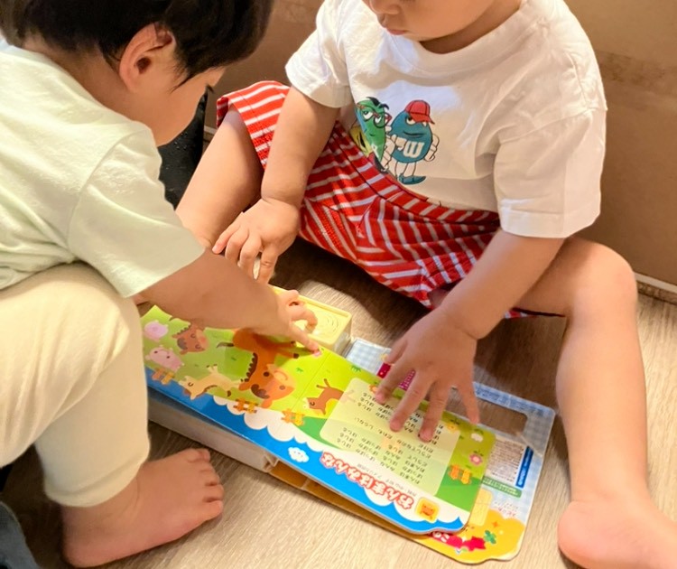 音が鳴る絵本で一緒に遊ぶ0歳児と1歳児
