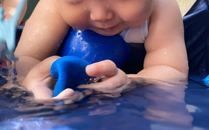 甲子園口園で水遊びをする0歳児