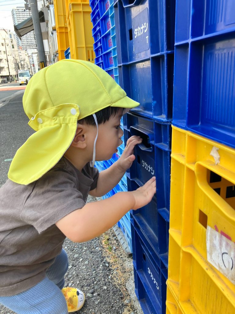 南堀江付近をお散歩中に見つけたプラスチックケースを覗く園児