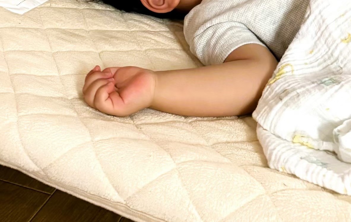 PEEK A BOO保育園 三宮でお昼寝をしている1歳児の手
